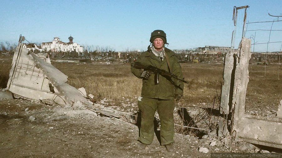 Russell Bentley on the background of the Iversky Monastery, which was destroyed during the fighting